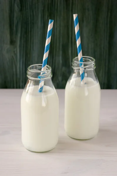 Retro milk bottle with striped drinking straw and further bottle