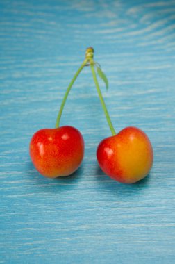 Mavi ahşap arka plan üzerinde meyveleri olgunlaşmış kiraz