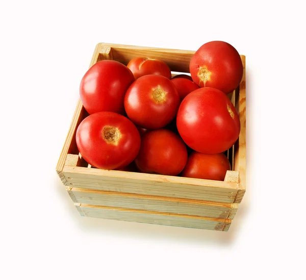 Färska tomater på rankan i en trälåda på en vit ba — Stockfoto