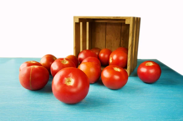 Färska tomater på blå bord — Stockfoto