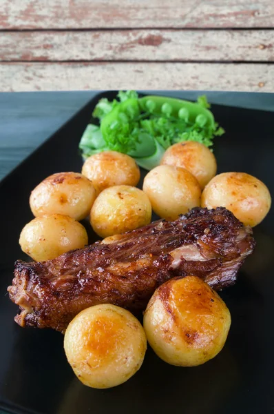 Kuzu pirzola kavrulmuş patates ve sarımsak ile.