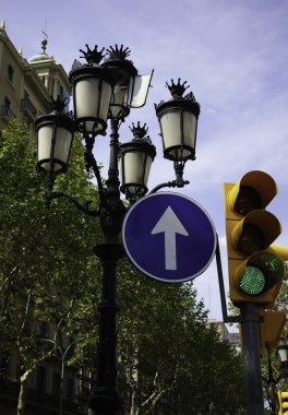 Trafik ışığı ve sokak lambasına iliştirilmiş trafik levhası.