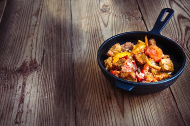 Tatlı biber ve domates ahşap doğru ile kavrulmuş domuz eti