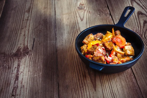 Tatlı biber ve domates ahşap doğru ile kavrulmuş domuz eti