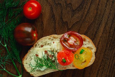 Peynirli tam tahıllı ekmek veya sandviç, domates, soğan, dereotu, ahşap zemin üzerinde keten tohumu.
