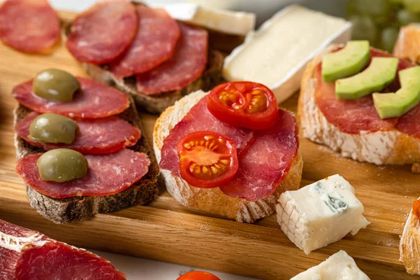 Assortment of sausages and cheese, salami, olives, on white background. Close up — Stock Photo, Image