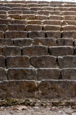 Eski tuğla merdivenlerin dikey fotoğrafı. Antik taş merdivenler güneş ışığına çıkıyor. Kahverengi tarihi basamaklar güneşi yansıtıyor. Yıpranmış kentsel basamakların inşası.