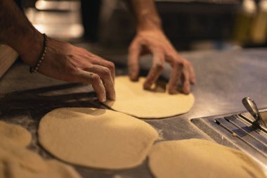 Aşçı hamuru dışarı atıyor. Unlu masa.