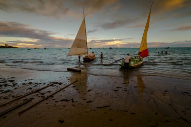 Sunset and tourist boats on a beach in Maceio, Brazil