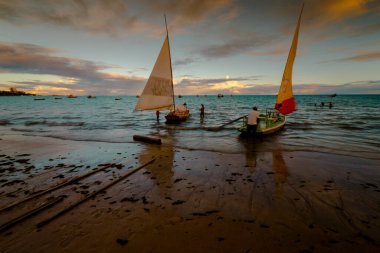 Sunset and tourist boats on a beach in Maceio, Brazil