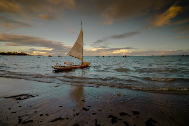 Sunset and tourist boats on a beach in Maceio, Brazil