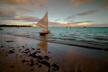 Sunset and tourist boats on a beach in Maceio, Brazil