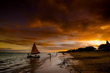 Sunset and tourist boats on a beach in Maceio, Brazil