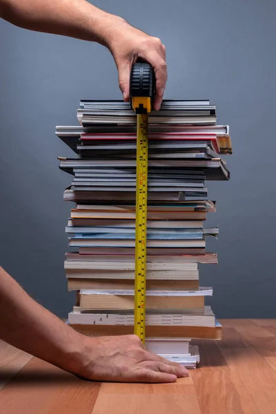 Bilgiyi temsil eden dağ kadar kitap boyutunda bir insanın elleri.