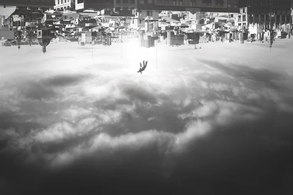 Людина падає з догори дригом міста — стокове фото