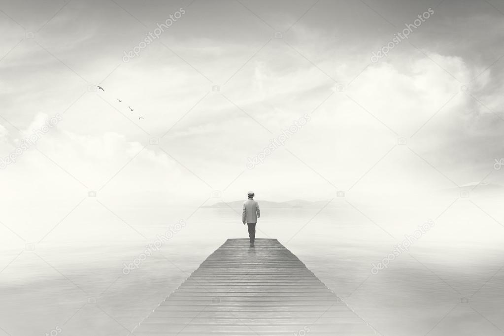 Man walking on a boardwalk in the fog