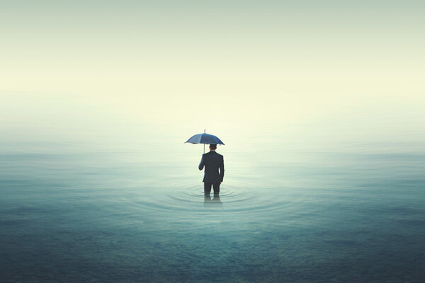 Wet business man walking into water