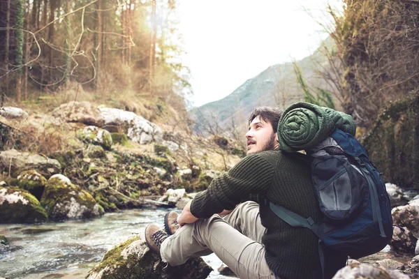 Man zit in de buurt van de kreek voelen de sfeer van het bos — Stockfoto