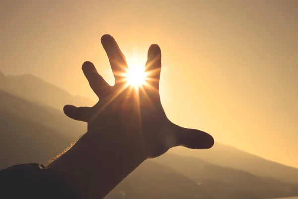 Hand trying to grab the sun — Stock Photo, Image