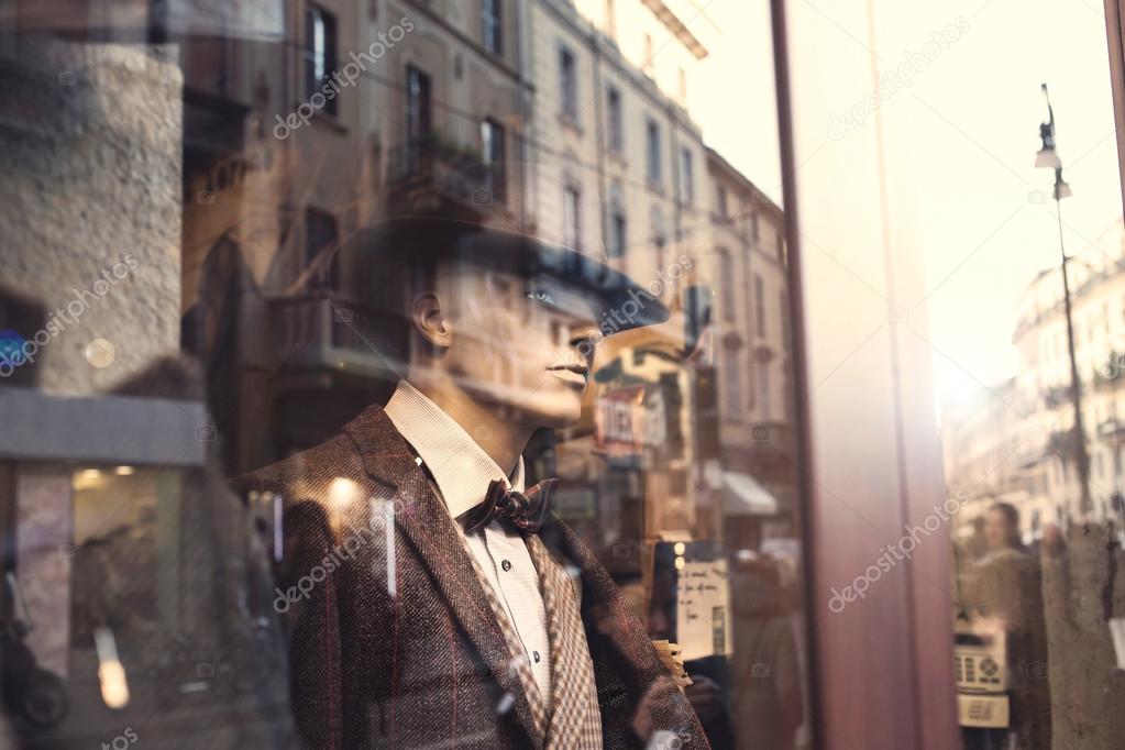 Well dressed Man behind a window watching people in the street