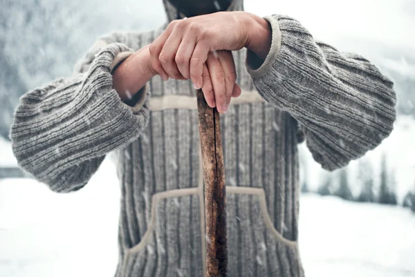 Muž do divoké zimní s kusem dřeva při sněžení — Stock fotografie