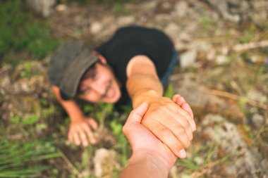 Hand helping a man to raise after falling clipart