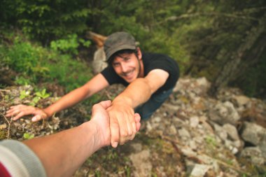 Kletterer, die einander helfen, in den Berg zu besteigen