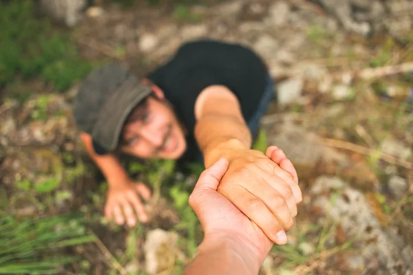 Mão ajudando um homem a levantar depois de cair — Fotografia de Stock