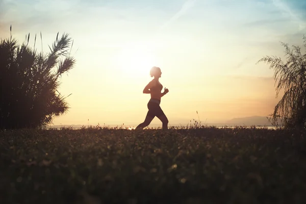 Mujer corriendo en la naturaleza al atardecer —  Fotos de Stock