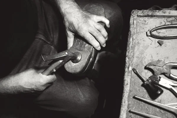 Alter Schuhmacher schlug in seiner Werkstatt mit Hammer auf Schuhe ein — Stockfoto