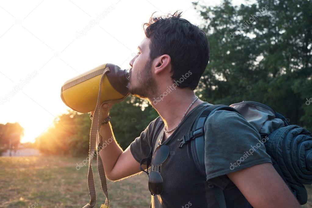 thirsty Adventurer hiker drinking fresh water hot