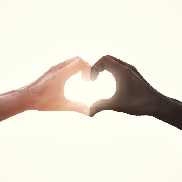 Interracial pareja en amor corazón forma mano gesto — Foto de Stock