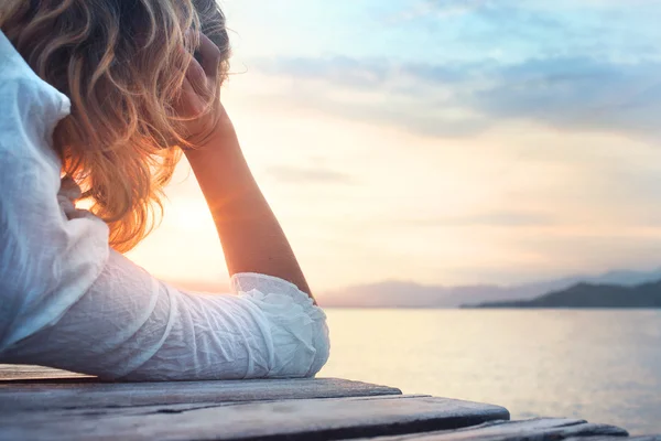 Mujer melancólica observando la puesta de sol — Foto de Stock