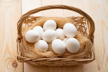 Tahta masaya saçılmış beyaz yumurtalar. Çiftliğin ürünleri..
