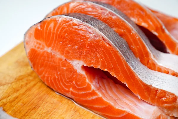 Tahta bir kesme tahtasında parçalara ayrılmış somon balığı. kırmızı balık. 