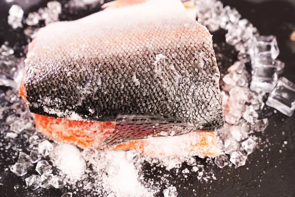 Buz küplü siyah taş bir tahtanın üzerinde somon balığı. kırmızı balık. — Stok fotoğraf