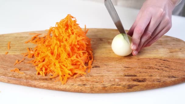 Rebanar con un cuchillo de cebolla en una tabla de cortar de madera. — Vídeo de stock