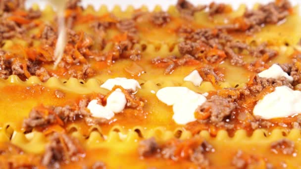 Laying of layers of lasagna into a baking dish. pasta casserole with sauce. — Stock Video