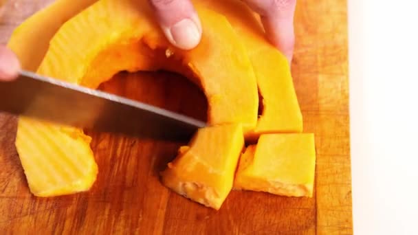 Rodajas de calabaza peladas cortadas en trozos en una tabla de cortar — Vídeos de Stock