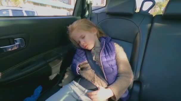 Маленька дівчинка заснула на задньому сидінні автомобіля . — стокове відео