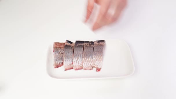 Salted herring peeled from the skin, entrails and bones are cut into pieces. — Stock Footage Salted herring peeled from the skin, entrails and bones are cut into pieces. Stock Footage