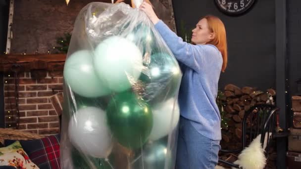 Kobieta rozpakowuje balony, by udekorować pokój na święta.. — Wideo stockowe