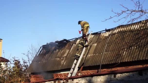 Strażacy pracują na dachu spalonego budynku. — Wideo stockowe