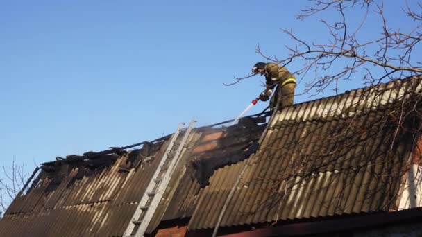 İtfaiyeciler yanmış bir binanın çatısında çalışır.. — Stok video