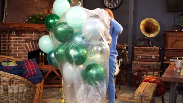 En kvinna packar upp ballonger för att dekorera rummet för semestern. — Stockvideo