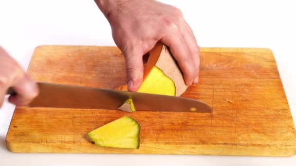Calabaza en rodajas pelada en una tabla de cortar con un cuchillo — Vídeos de Stock