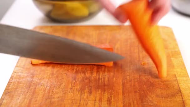 Raw carrots, onions and potatoes are cut into large cubes on a cutting board. — Stock Video