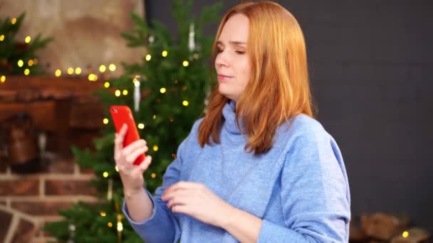 Γυναίκα καλεί μέσω video link κοντά στο χριστουγεννιάτικο δέντρο. Συγχαρητήρια σε φίλους — Αρχείο Βίντεο