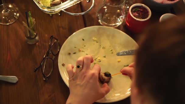 Baixa luz. Vista de cima. mãos das mulheres puxar o caracol cozido para fora da casca — Vídeo de Stock