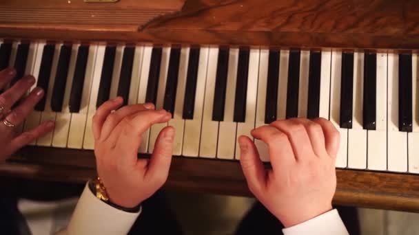 Mało światła. Widok z góry. męskie dłonie grają na klawiszach fortepianu. zarabianie na grę — Wideo stockowe